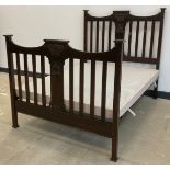 An Art Nouveau stained hardwood double bed frame, carved head and footboard, 144cm high x 137cm wide