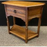 An Old Charm style oak hall table, canted rectangular top, single drawer to frieze, shelf to base,