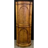 A 19th century burr walnut, bow-front corner cupboard, satin and boxwood inlay, arched panel