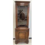 A Georgian style reproduction mahogany corner cabinet, moulded cornice, Astral-glazed door to top,