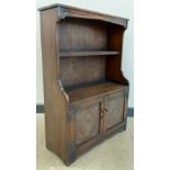 An Old Charm style oak bookcase cupboard, two tiers of open shelving to top, pair of carved cupboard