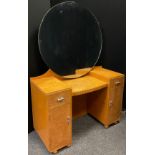 An Art Deco Quilted Maple dressing table, large circular mirror to top, small drawer, and cupboard