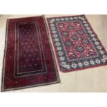 A Middle Eastern woollen rug / carpet, hand-knotted in red and black, 192cm x 106cm; another carpet,