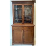 An Edwardian Mahogany bookcase cabinet, dentil cornice, above a pair of glazed doors enclosing three