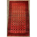 A North East Persian Turkoman rug / carpet, hand-knotted in red and black, 165cm x 93cm.