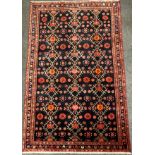 A North west Persian Hamadan rug / carpet, hand-knotted with stylised flowers in tones of red,