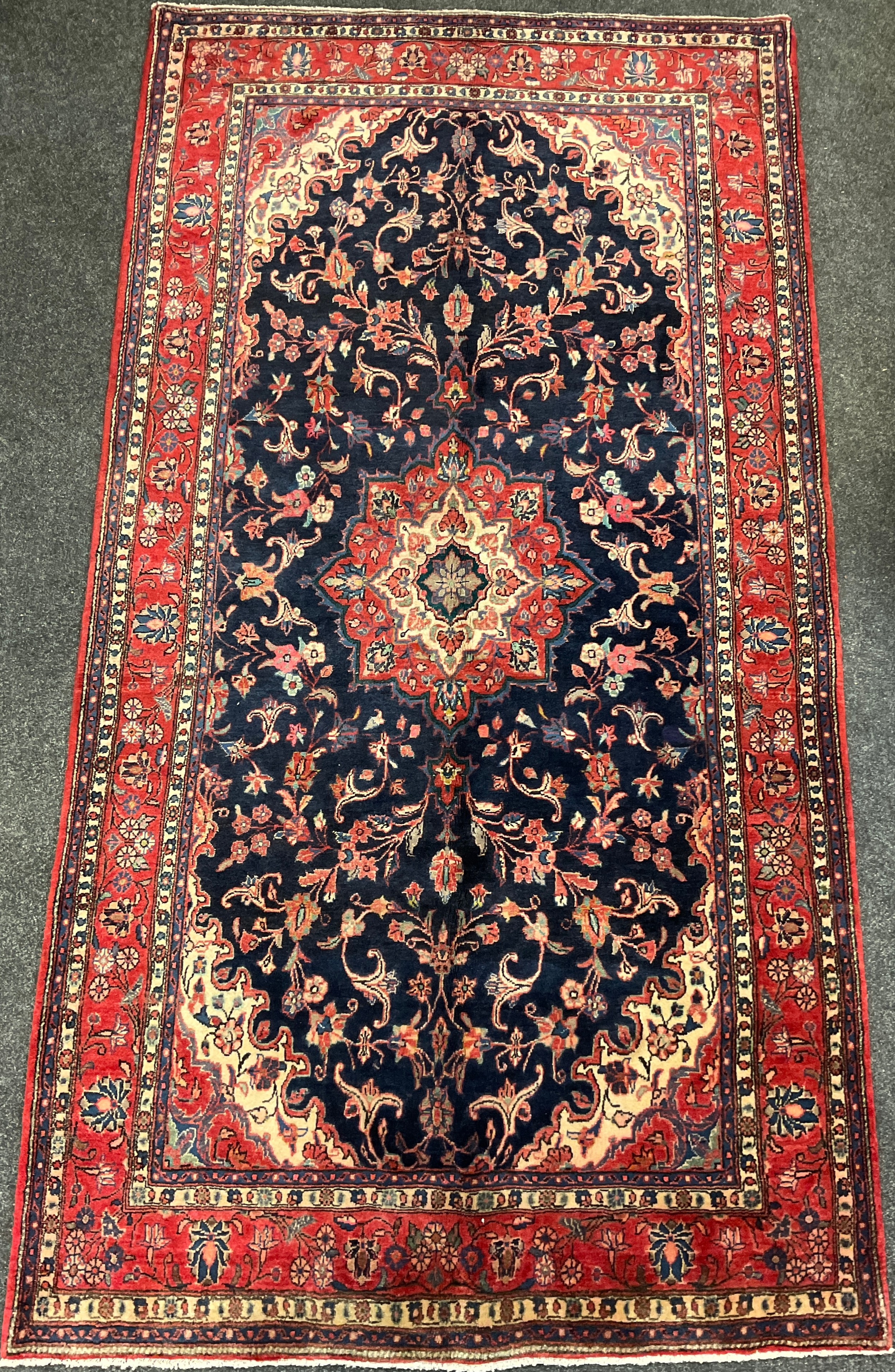 A central Persian Sarouk carpet, hand-knotted with a central lotus form medallion, within a stylised