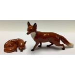 A Beswick model of a fox curled sleeping, printed mark, green sticker, 10cm wide; another walking