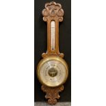 An early 20th century Android Barometer, carved oak case , silvered thermometer and barometer