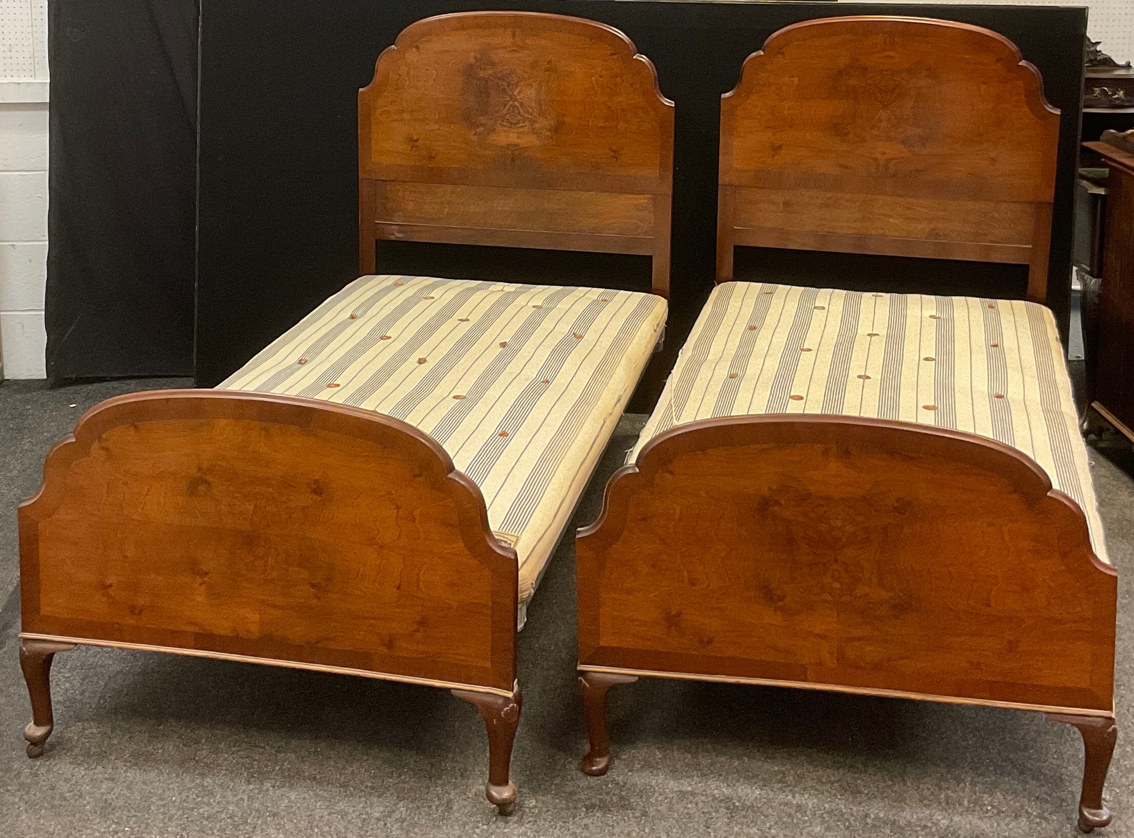 A pair of early to mid 20th century single beds - walnut head and foot boards, cast iron side rails,