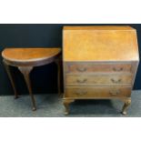 A reproduction walnut veneer bureau, fall door to top enclosing fitted interior, above three