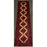 A North West Persian Hamadan runner carpet, hand-knotted in tones of red, blue, turquoise and cream,