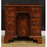 A George III style kneehole desk, rectangular top with inset tooled and gilt writing surface above