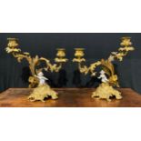 A pair of Rococo Revival gilt metal two-light candelabra, each cast with flowers and scrolling