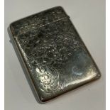An Edwardian silver rounded rectangular visiting card case, chased and engraved with foliate