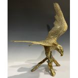 A large brass model of an eagle, perched on a branch, 58cm high