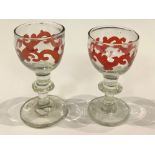 A pair of early 19th century hand spun Port glasses, red/brown enamel flashes, knopped stems,