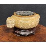 A Chinese soapstone censer, carved in the Archaic taste, pierced hardwood cover, 18cm wide, hardwood