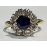 An 18ct gold diamond and sapphire flower head cluster ring, the central faceted sapphire
