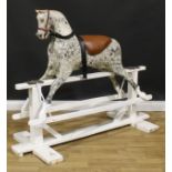 An early 20th century carved softwood dapple rocking horse, trestle base, 125cm high, 154cm long