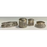 An Edwardian silver lozenge shaped dressing table jar, embossed with leafy scrolls, hinged cover,