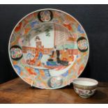 A Japanese porcelain bowl, the central section painted with figures in traditional interior,