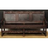 An 18th century oak settle, possibly Cheshire, shaped cresting rail carved with acanthus flanked