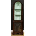 A Regency style mahogany corner drawing room cabinet, the shaped niche moulded with a scallop, the