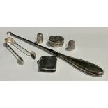 A silver vesta case; a silver hafted boot hook; two silver thimbles; a pair of silver sugar bows;