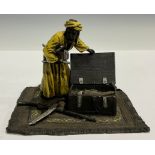 A cold painted bronze, as an Arab opening a chest of weapons, 11cm high