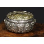 A 19th century Burmese silver circular bowl, repousse chased with deities and scrolling foliage,