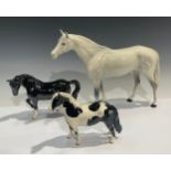 A Beswick model, of a Pinto Pony, 17cm high; a Beswick model, of a Dapple Grey Horse, 28cm high;