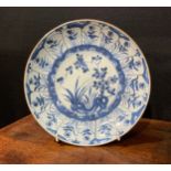 A Chinese circular dish, painted in tones of underglaze blue with flowers and rock work, Kraak
