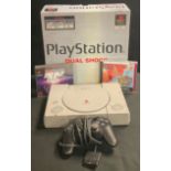 A PlayStation One, Dual Shock, one controller, boxed with two games