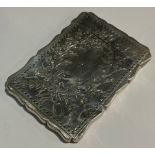 A Victorian silver shaped rectangular visiting card case, engraved with a ribbon tied leafy garland,