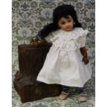 A reproduction bisque head and painted composition bodied black doll, the bisque head inset with