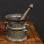 A cast iron pestle and mortar, flared rim above a quarter girdle, angular lug handles, skirted base,