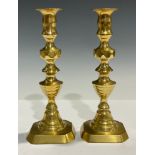 A pair of brass ejector candlesticks, 24cm high