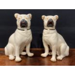 A pair of 19th century Staffordshire models of pugs, seated to left and right, painted features,