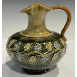 A Royal Doulton jug, tube lined with a band of trailing leaves and blue blossom on a mottled green
