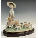 A Lladro figure group, My Little Explorers, walking the dogs, number 6828