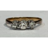 An 18ct gold, three stone diamond ring, central brilliant cut stone flanked by two smaller, size