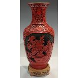 A Chinese cinnabar lacquer type baluster vase, decorated with peonies within a fretwork trellis,