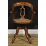 A late Victorian/Edwardian oak swivel desk chair, 90.5cm high, 61cm wide, the seat 42cm wide and