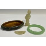 A Chinese oval dish; a jade figure; a bangle; a small carving