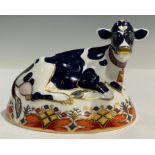A Royal Crown Derby paperweight, Friesian Cow 'Buttercup', 21st anniversary gold stopper, printed