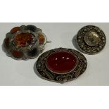 A Scottish silver and agate brooch; a thistle brooch; an oval agate set brooch