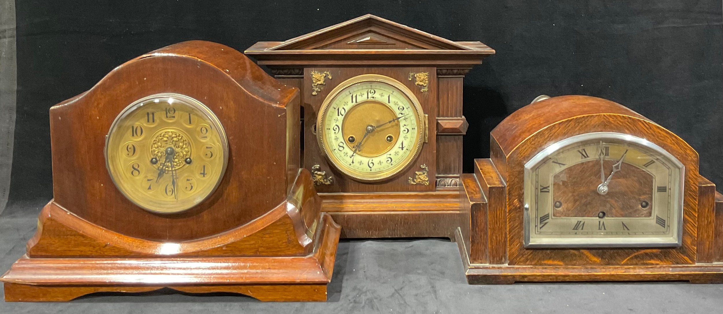 A late 19th century oak architectural mantel clock, arched pediment, the dial flanked by columns,