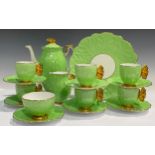 An Art Deco Aynsley coffee set for six, modelled with butterfly handles in yellow, apple green