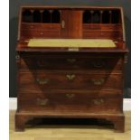 A George III mahogany bureau, fall front enclosing a small door, small drawers and pigeonholes,